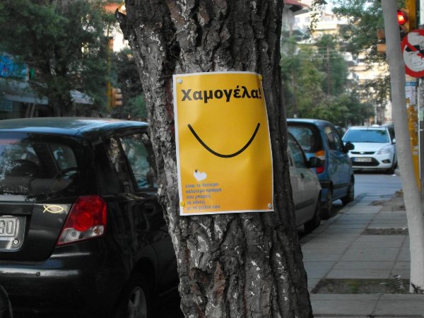 Poster on tree: Smile! It's the second best thing you can do with your lips.