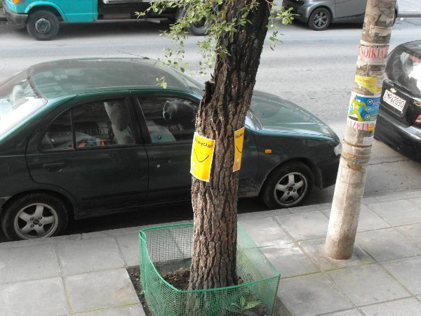 Poster on tree: Smile! It's the second best thing you can do with your lips.